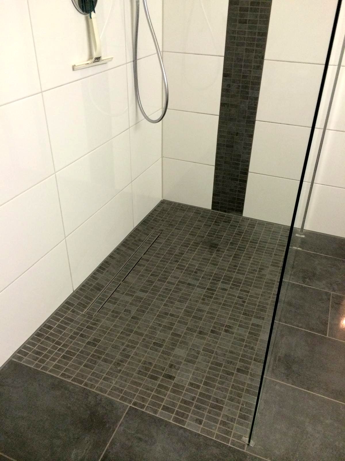 Bodengleiche Dusche mit grauem Feinmosaik, Edelstahl-Linienablauf und weißen Wandfliesen