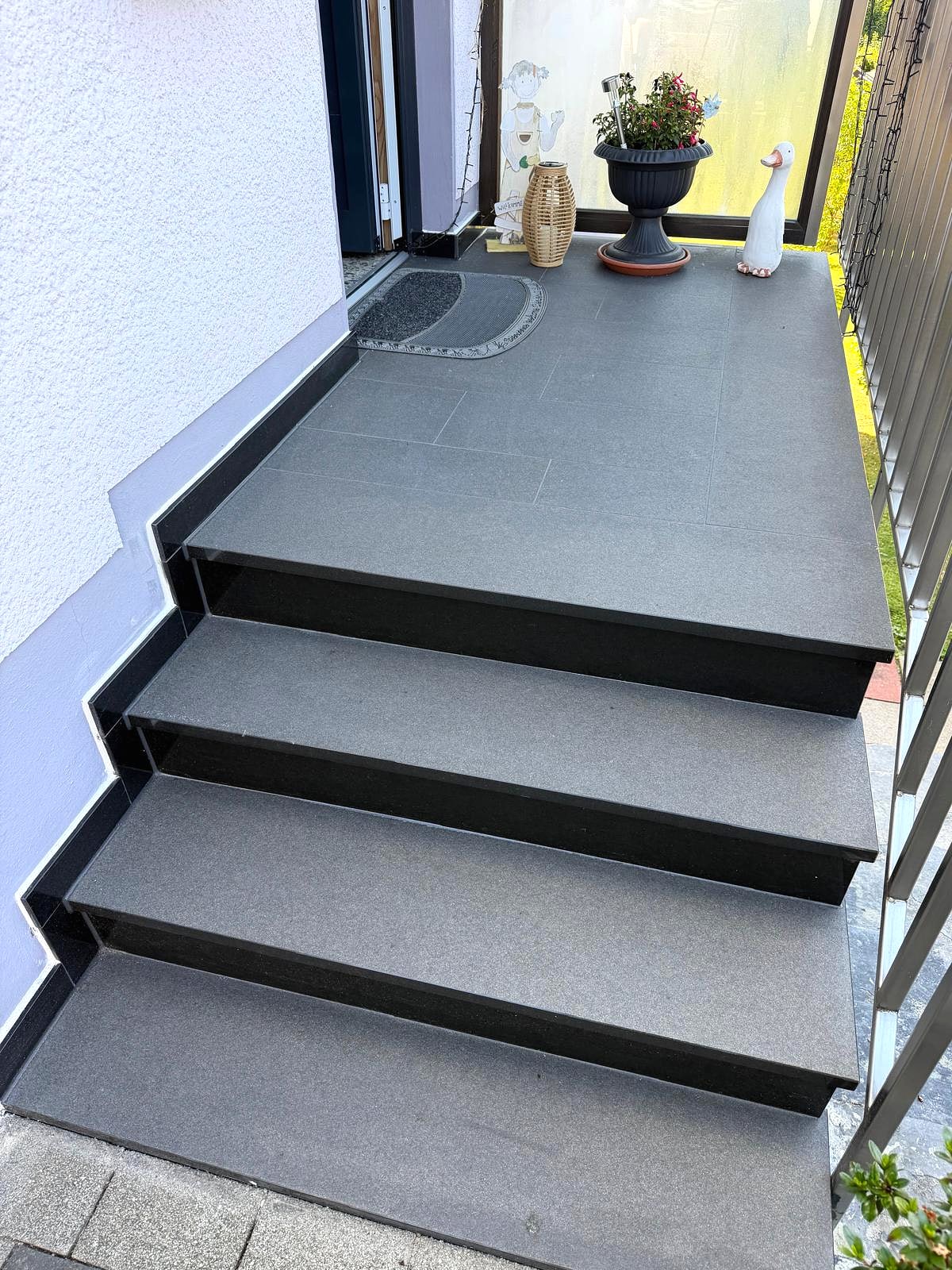 Hauseingang mit Podest und Stufen aus dunklem Granit