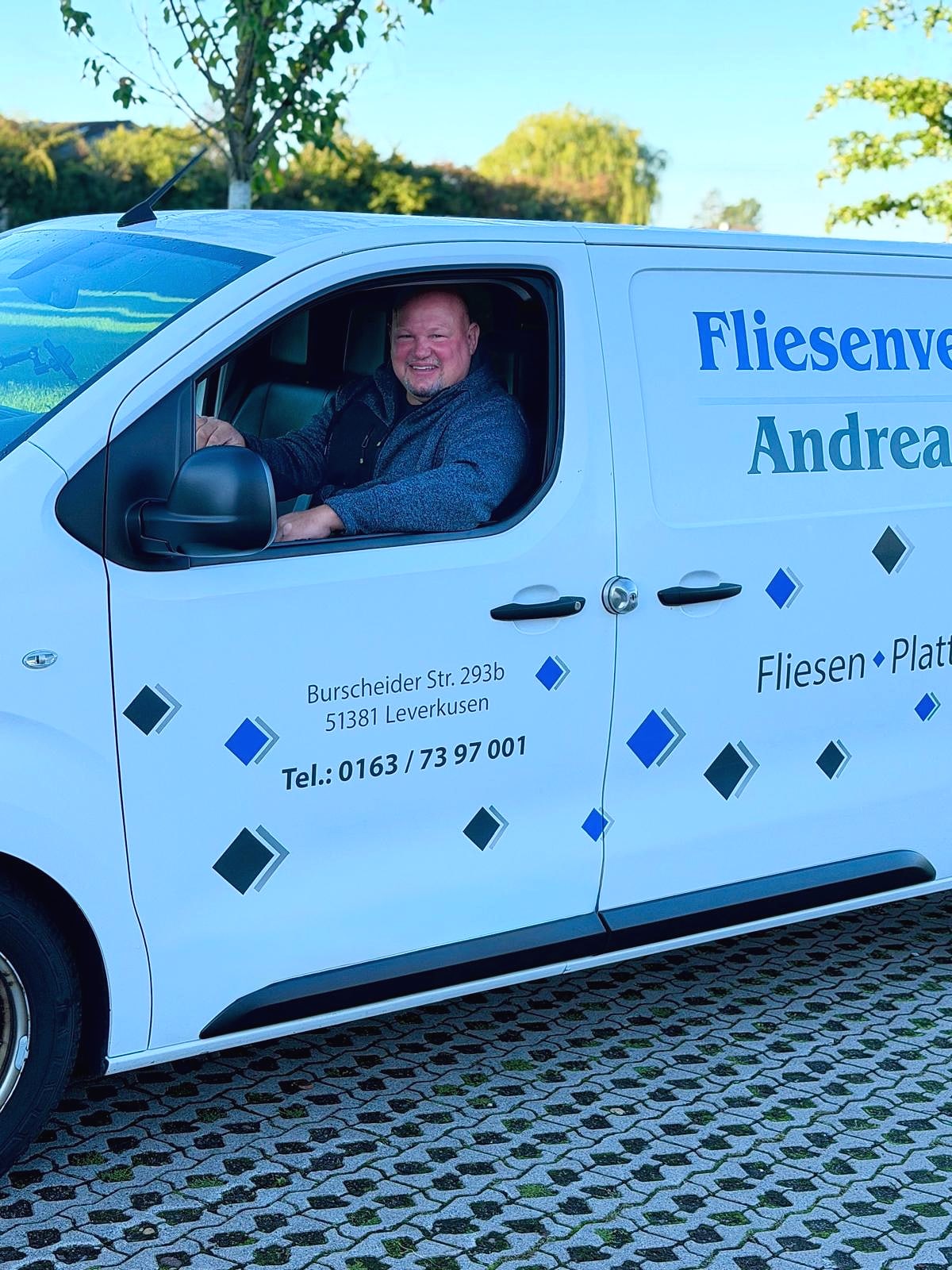 Andreas Wolff am Steuer des beschrifteten Firmenwagens der Fliesenverlegung Andreas Wolff